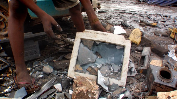 a young boy smashes a computer monitor in Ghana